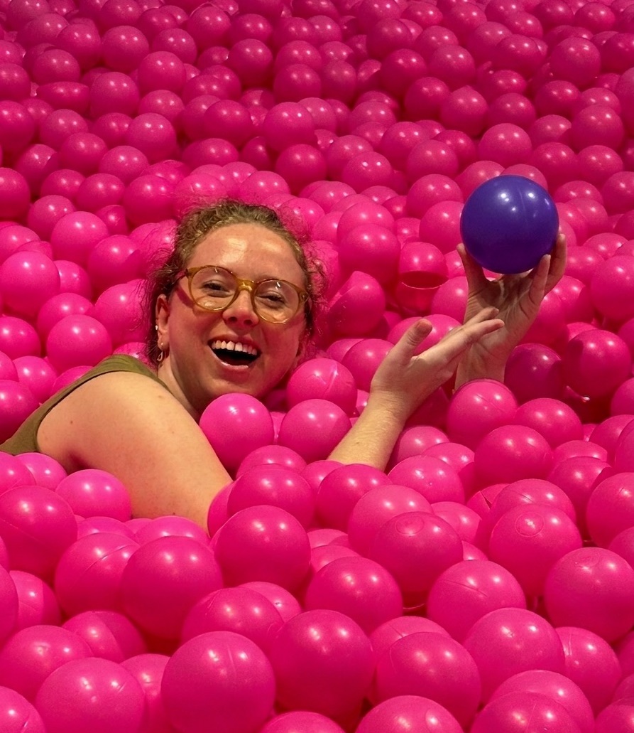 Freya in a ballpit, finding wine